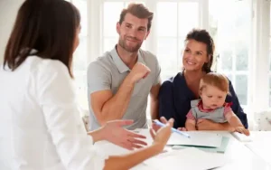 Padres con niño pequeño consultando hipoteca mixta con asesor en oficina bancaria en Córdoba