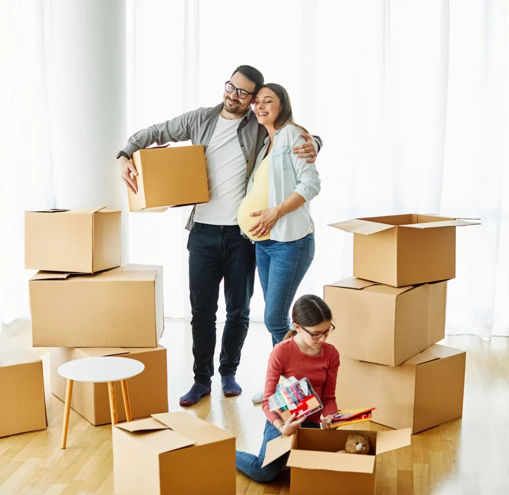 Familia con una niña preparando cajas en casa nueva