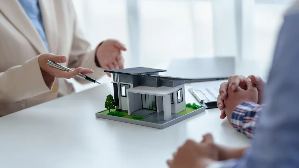 Profesional explicando una vivienda en maqueta durante la gestión de obra nueva en Córdoba