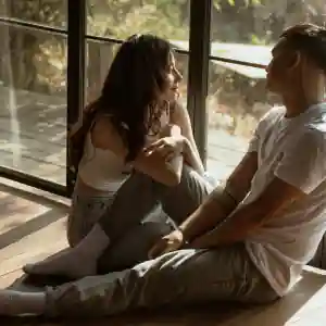 Pareja sentada junto a una ventana en una vivienda mientras valora una hipoteca 100 en Córdoba