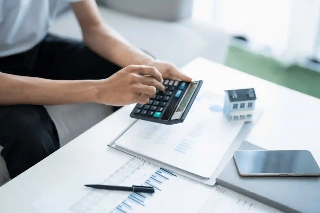 Persona calculando una hipoteca 90 con documentos de financiación de vivienda