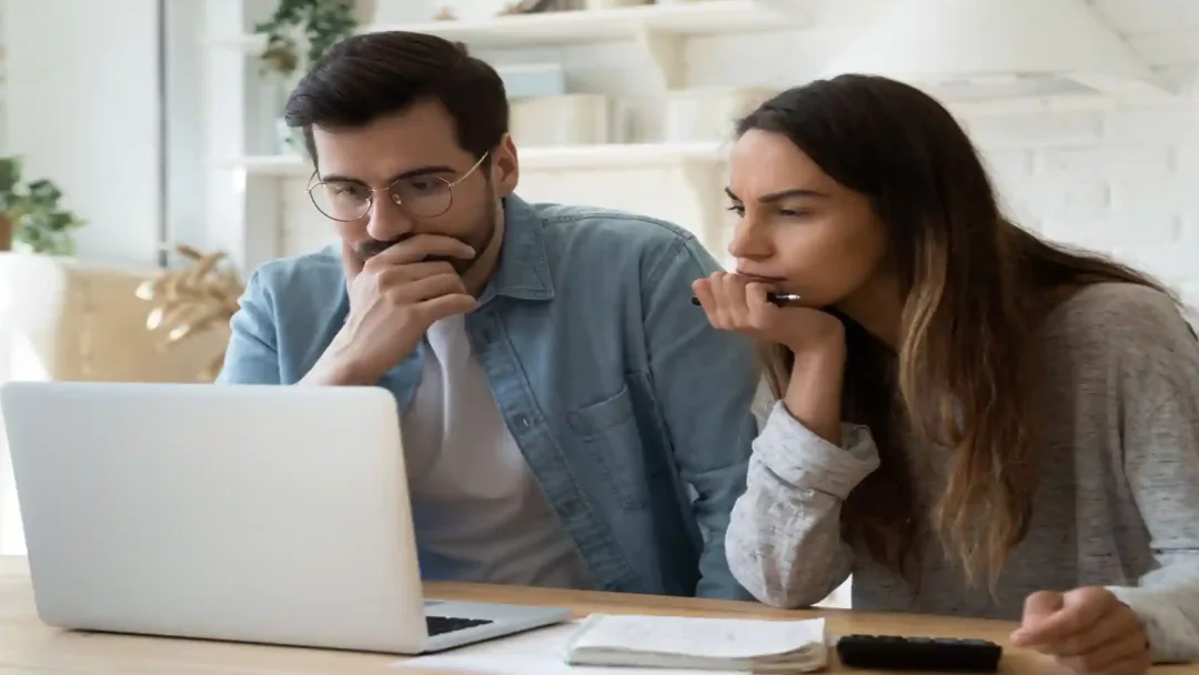 Pareja revisando condiciones antes de comprometer una compra de vivienda