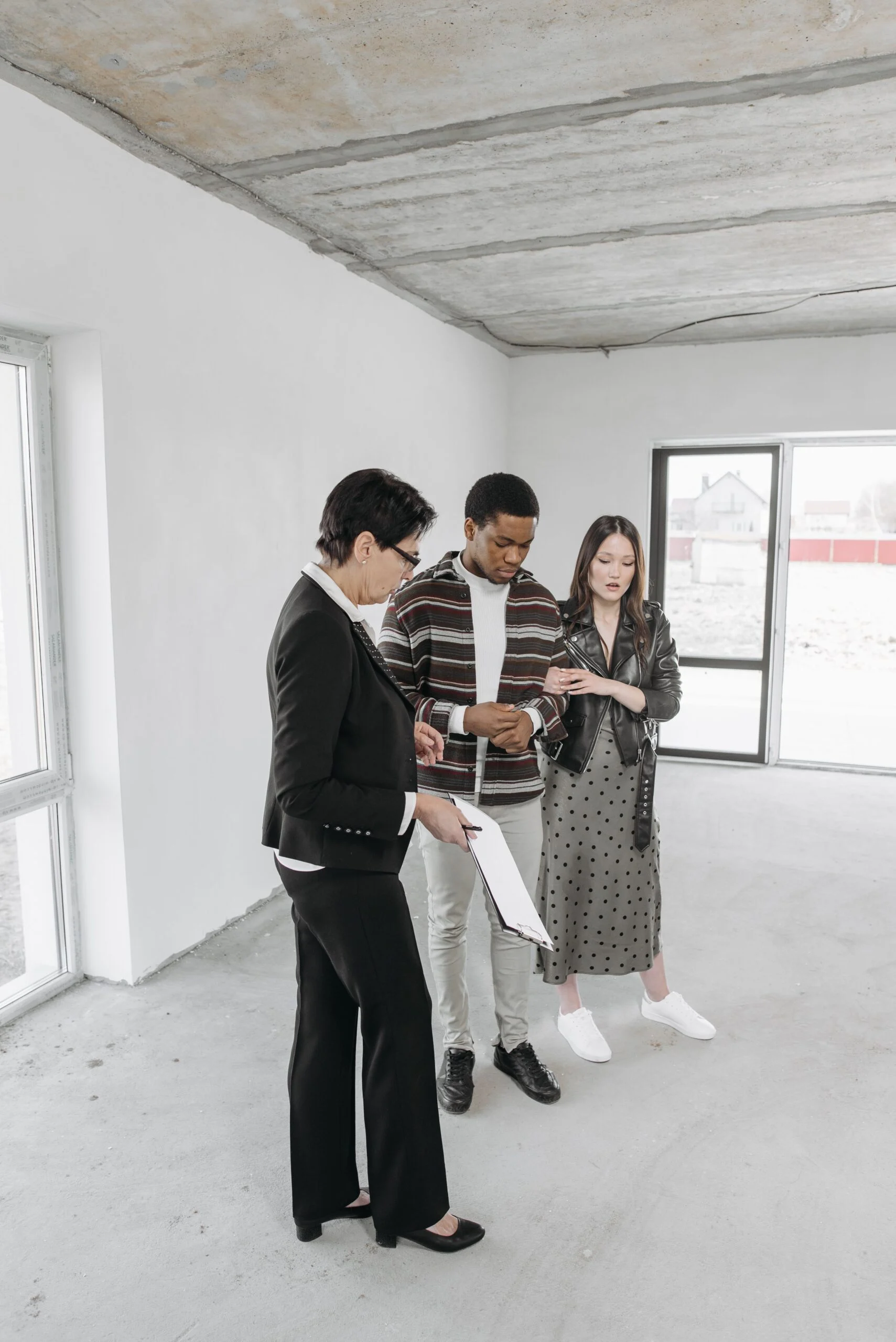 Pareja revisando información de una vivienda durante una visita con una profesional