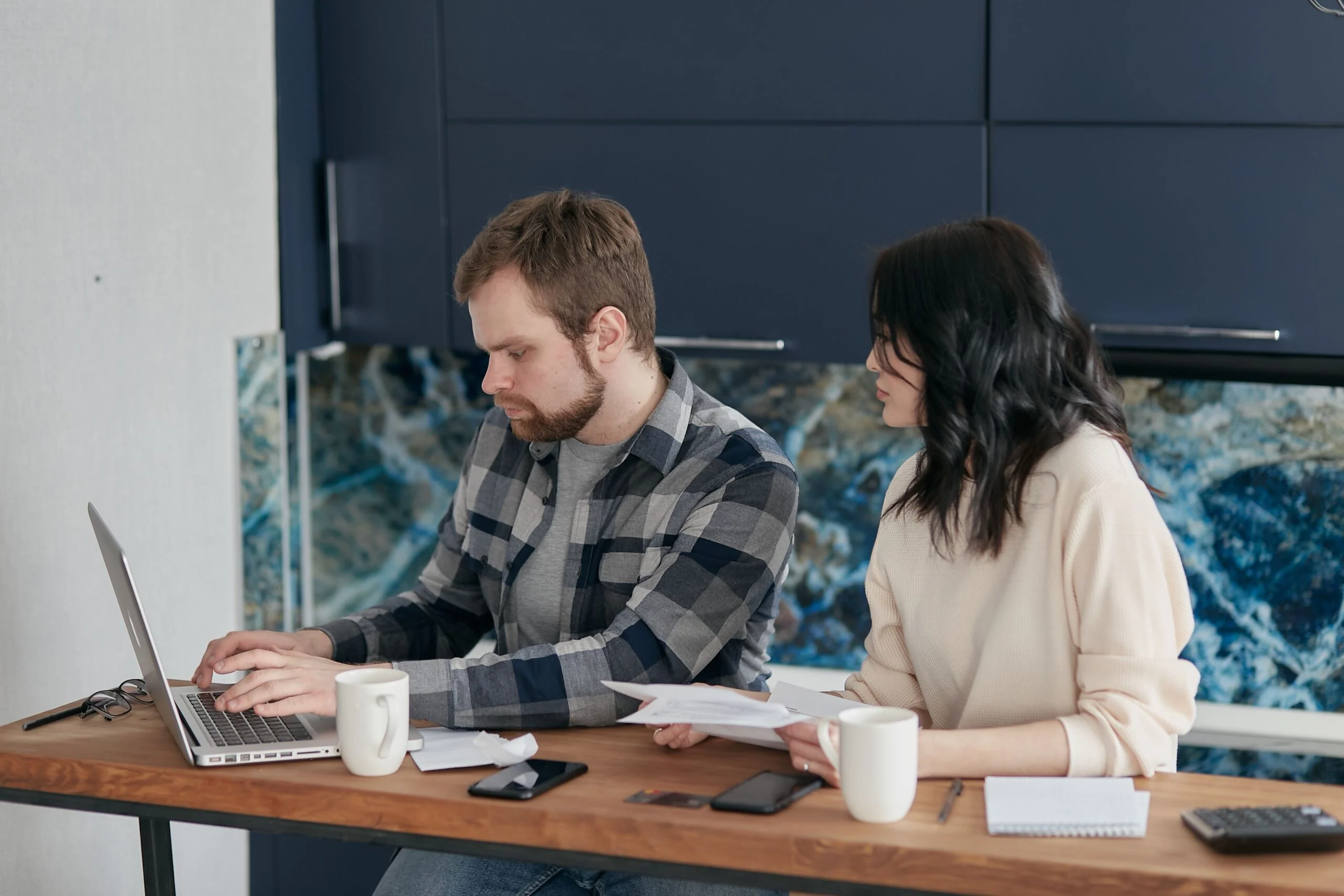 Pareja revisando sus finanzas con ordenador y documentación